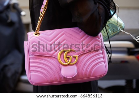 MILAN - JUNE 17: Woman with Gucci pink leather bag with golden chain before Versace fashion show, Milan Fashion Week street style on June 17, 2017 in Milan.