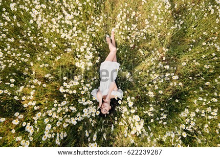 stock photo beautiful woman lying down in daisy field 622239287