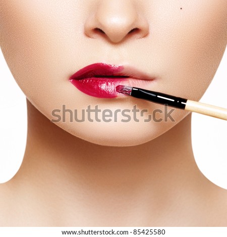 Part of attractive woman's face with fashion red lips makeup. Make-up artist apply bloody lipstick