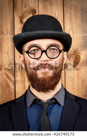 Elegant man wearing suit, bowler hat and spectacles. Old style fashion.