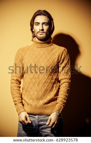 Handsome man wearing yellow pullover. Men's beauty, fashion. Hairstyle for men. Yellow background.