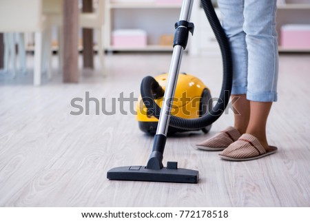 Woman doing cleaning at home with vacuum cleaner