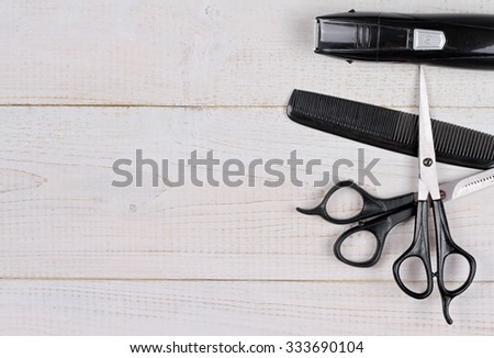 Scissors and comb on white rustic wooden background. Hairdresser salon concept. Haircut accessories