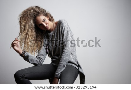 women touching her blond curly hair