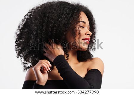 black woman touches her curly hair