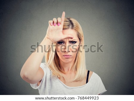 stock photo closeup portrait unhappy woman giving loser sign on forehead looking at you with anger and hatred 768449923
