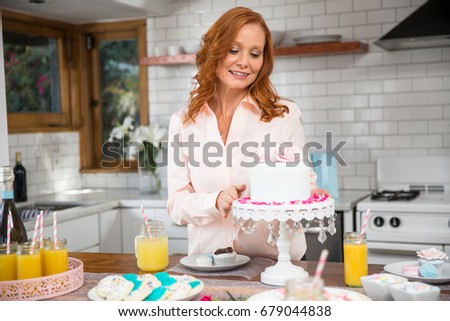 retired woman at kitchen home decorating house for a party family gathering with cake - Woman Home Decorating retired woman at kitchen home decorating house for a party family gathering with cake - Woman Home Decorating
