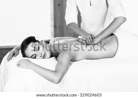 Young beautiful girl lying on massage table and enjoying massage.
