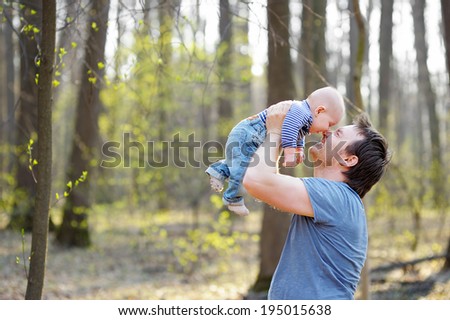 Happy middle age man holding his little baby