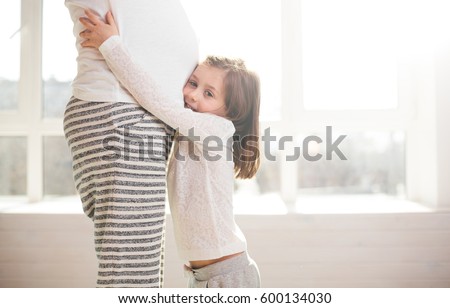 Pregnant woman and a child hugging
