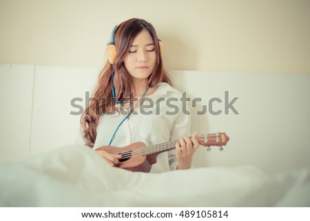 https://thumb1.shutterstock.com/display_pic_with_logo/715066/489105814/stock-photo-young-lady-playing-ukulele-in-her-bedroom-lighting-with-sun-flare-and-sweet-vintage-489105814.jpg