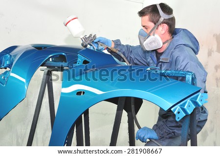 Worker spraying gray base coat.