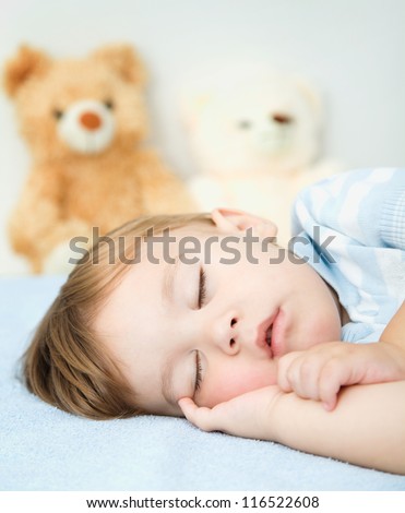 Cute little boy is sleeping on a white pillow