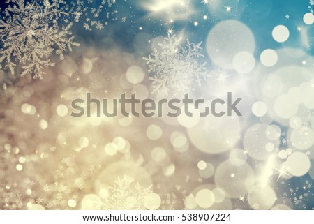 Magic blue holiday abstract glitter background with blinking stars and falling snowflakes. Blurred bokeh of Christmas lights.