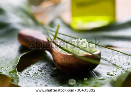 Green bath salt on wooden spoon