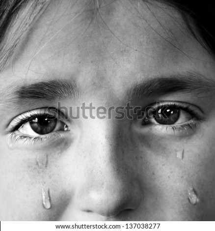 Portrait of little girl crying with tears rolling down her cheeks