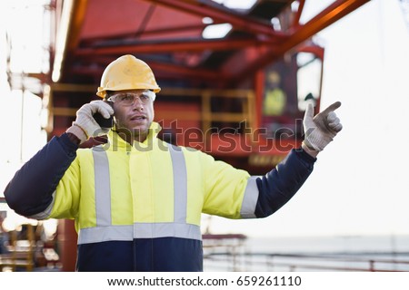 Worker using walkie talkie on oil rig