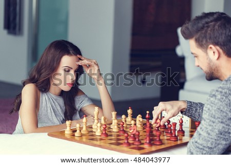 Casual caucasian woman thinking during chess game indoor