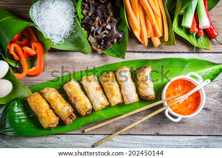 Fried spring rolls surrounded by ingredients