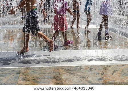 children playing with water in park fountain. Hot summer. Happy children have fun playing in water fountains