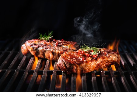 Beef steaks on the grill with flames