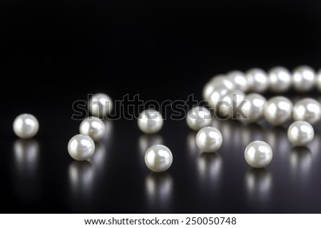 White pearls necklace on black background