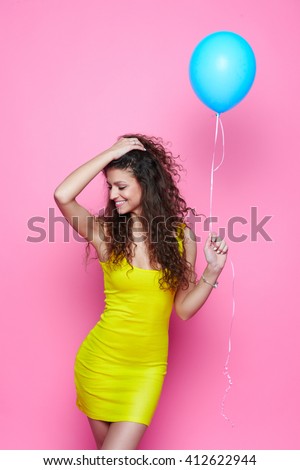 https://thumb1.shutterstock.com/display_pic_with_logo/754942/412622944/stock-photo-young-and-beautiful-curly-girl-in-a-yellow-dress-on-a-pink-background-holding-blue-balloon-and-412622944.jpg