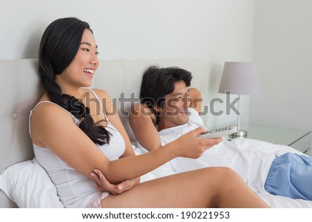https://thumb1.shutterstock.com/display_pic_with_logo/76219/190221953/stock-photo-smiling-asian-couple-lying-on-bed-watching-tv-at-home-in-bedroom-190221953.jpg