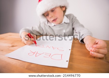 Child writing letter to santa at the desk