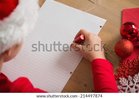 Little girl writing letter to santa at christmas at home in the living room