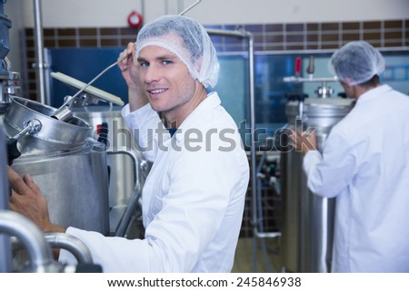 Portrait of a smiling scientist working with brewer in the factory