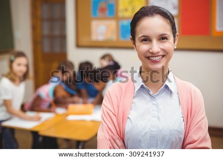 Teacher smiling at camera in classroom at the elementary school