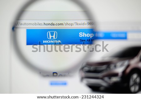 LISBON, PORTUGAL - NOVEMBER 17, 2014: Photo of Honda homepage on a monitor screen through a magnifying glass.