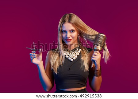 Portrait of female stylist standing with hairdresser's accessories