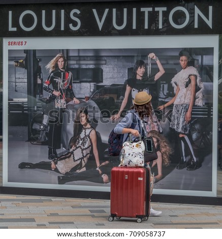 TOKYO, JAPAN - SEPTEMBER 1ST, 2017. Woman walking in front of Louis Vuitton outlet at Tokyo Station.