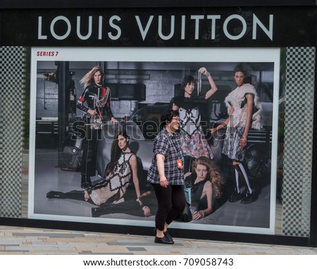 TOKYO, JAPAN - SEPTEMBER 1ST, 2017. Woman walking in front of Louis Vuitton outlet at Tokyo Station.