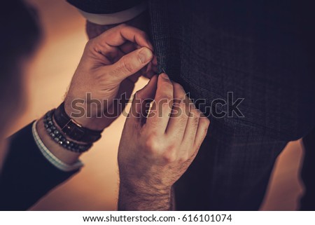 Tailor working with custom made suit