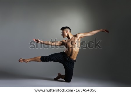 Young and stylish modern ballet dancer on grey background