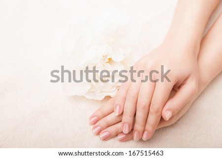 Beautiful hand with perfect nail french manicure and white flower