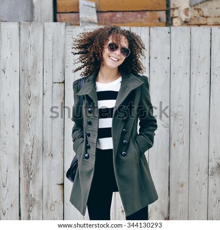 Beautiful young stylish woman with curly hair