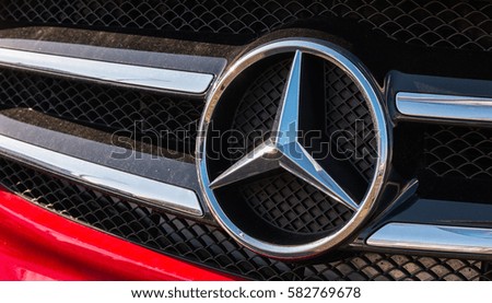 AACHEN, GERMANY FEBRUARY, 2017: Mercedes Benz logo on a red car grill. Mercedes-Benz is a German automobile manufacturer. The brand is used for luxury automobiles, buses, coaches and trucks.