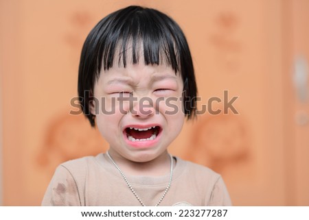 portrait of a cute little girl crying