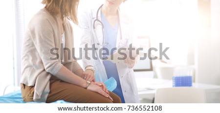 Doctor and patient discussing something while sitting at the table . Medicine and health care concept. Doctor and patient