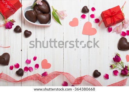 hộp quà tặng valentine và hình trái tim màu đỏ trên bàn gỗ trắng