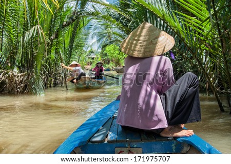 VINH LONG, VIETNAM - MARCH 6: Vietnamese woman paddling a traditional boat in the Mekong delta on March 6, 2009 near Vinh Long. The Mekong river is a major route for transportation in Southeast Asia.