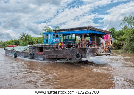 VINH LONG, VIETNAM - MARCH 7: Traditional colorful river boat cruising Mekong river on March 7, 2009 near Vinh Long. The Mekong river is a major route for transportation in Southeast Asia.