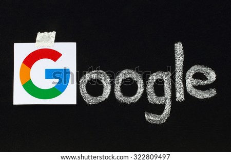 Kiev, Ukraine - September 02, 2015:New Google logotype printed on paper, cut and pasted on blackboard with chalk finish writing.Google is USA multinational corporation.
