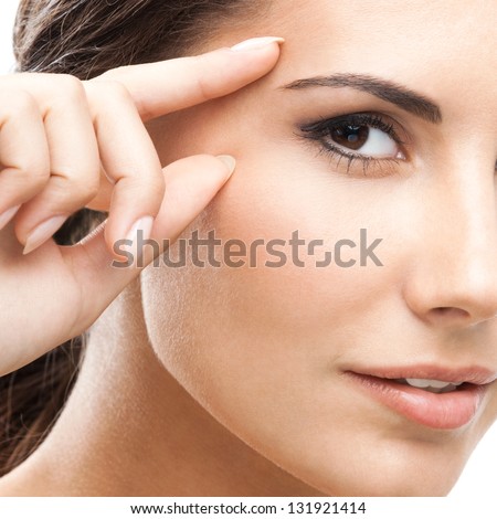 Portrait of happy smiling beautiful young woman touching skin or applying cream, isolated over white background