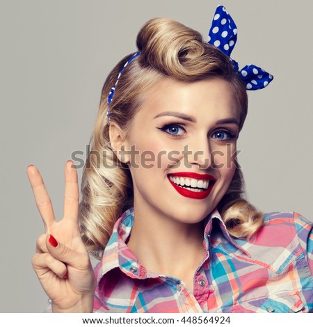 Portrait Of Beautiful Young Happy Smiling Woman Showing Two Fingers Or Victory Gesture Dressed Portrait Of Beautiful Young Happy Smiling Woman Showing Two Fingers Or Victory Gesture Dressed