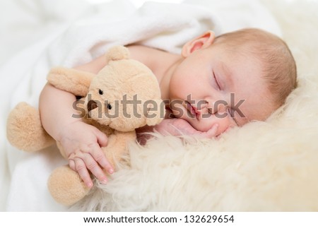 newborn baby sleeping on fur bed